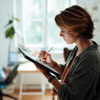 Woman taking notes on a tablet, using a stylus