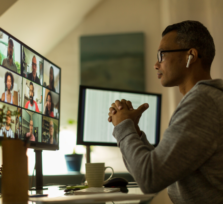 A man engaged in a group video call with his colleagues.